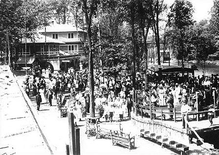 This scene shows the valley portion of the House of David Eden Springs Park as it looked when it first opened.  The large pond in the background at the far right and the large souvenir stand and circular stage in front of the pond dates this photo to about 1908-1910.  The benches in the right foreground appear to be made from the crude seats of the passenger cars purchased in New York in 1908.  These seats were turned into benches for the park and the north train depot on Britain Ave.  Since these cars and the engine purchased with them disappear from the record at about this time it is likely they were dismantled and parts recycled in the new locomotives, cars and other places in the park.