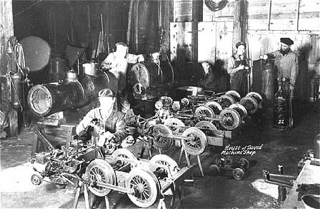 The first four 4-4-0 miniature locomotives built at the park are shown here disassembled in a colony machine shop.  This photograph does not represent the original construction according to Earl Boyersmith (second from the right in the picture), who lived close by the Colony (passed away July 25, 2006).  Every winter the locomotives and cars had to be overhauled because of the heavy use they received during the tourist season.  Each drive and guide wheel on the locomotives as well as the wheels on the passenger cars had to be machined on lathes to remove flat spots worn during the summer rail service.